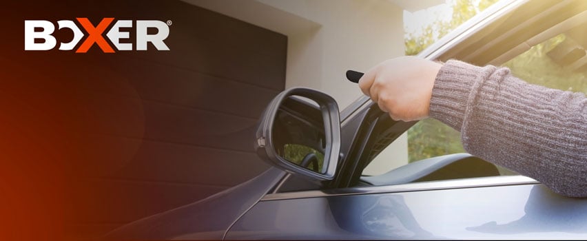 Boxer garageportåbner – person aktiverer automatisk garageport med fjernbetjening fra bil