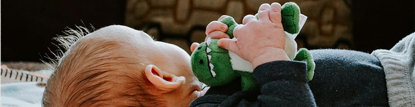 Poikavauva pehmolelu kädessään, lahjaideoita, jotka houkuttelevat leikkimään ja tarjoavat turvaa.