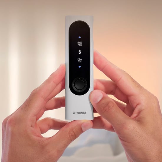 Withings terveysmittari – käsi pitää Withings monitoimista terveysskanneria lämpötilan ja terveystietojen mittaamiseksi